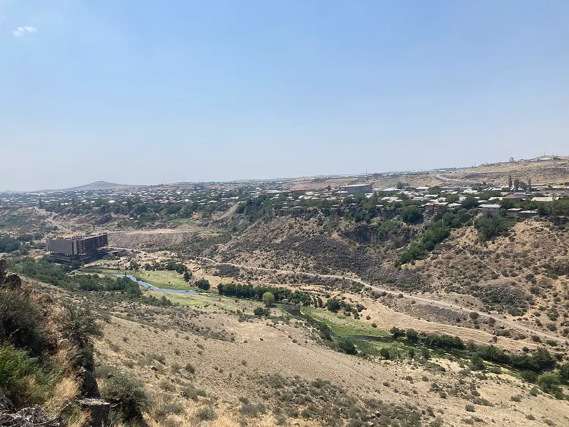 The dry Hrazdan river gorge at Arzni with a half-abandoned sanatorium block above the green riverbank