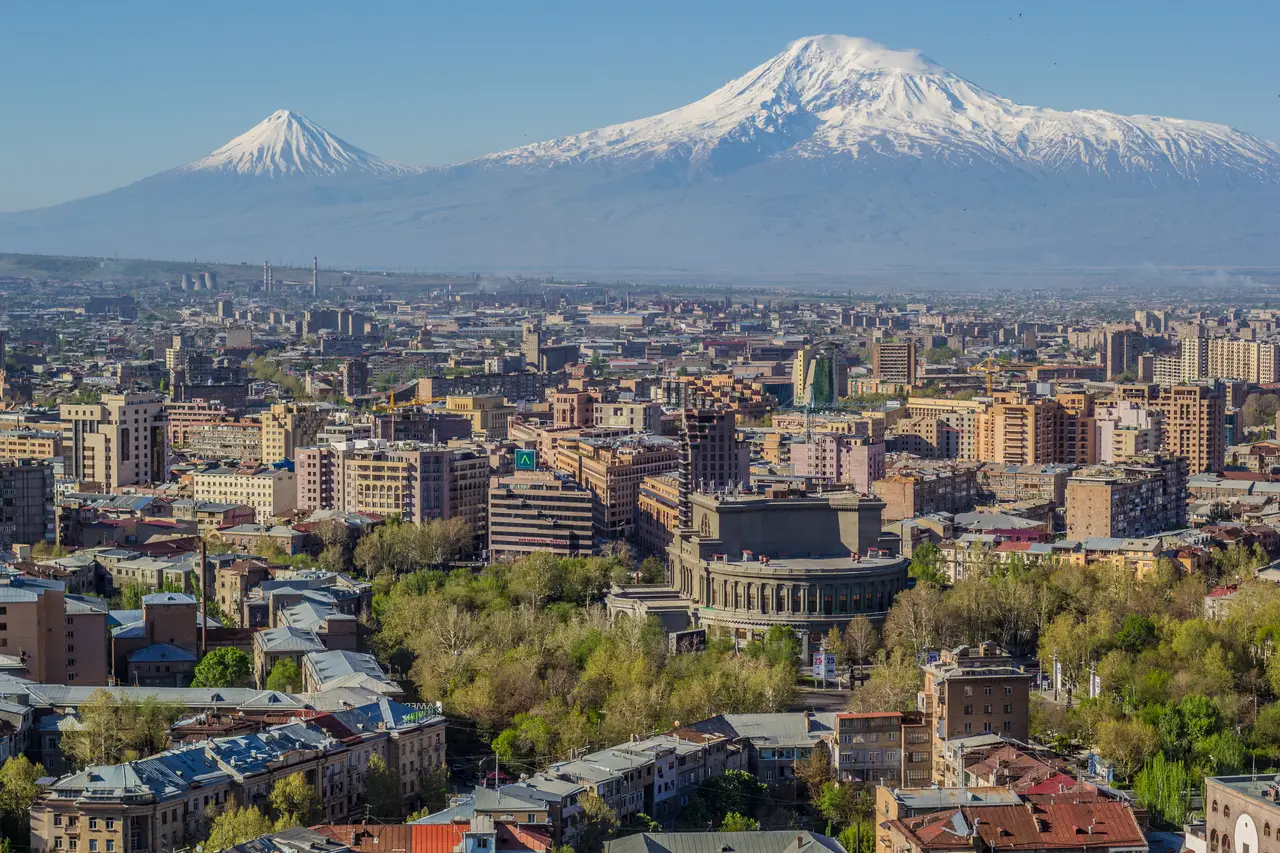 The Yerevan skyline spread out below the snow-capped double cone of Mount Ararat at dawn
