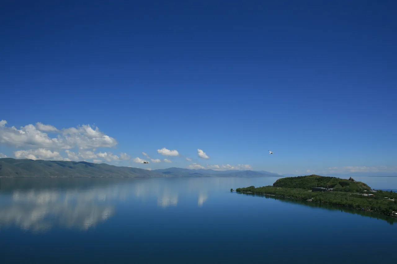 The blue expanse of Lake Sevan with the Sevanavank churches on their headland under a bright sky