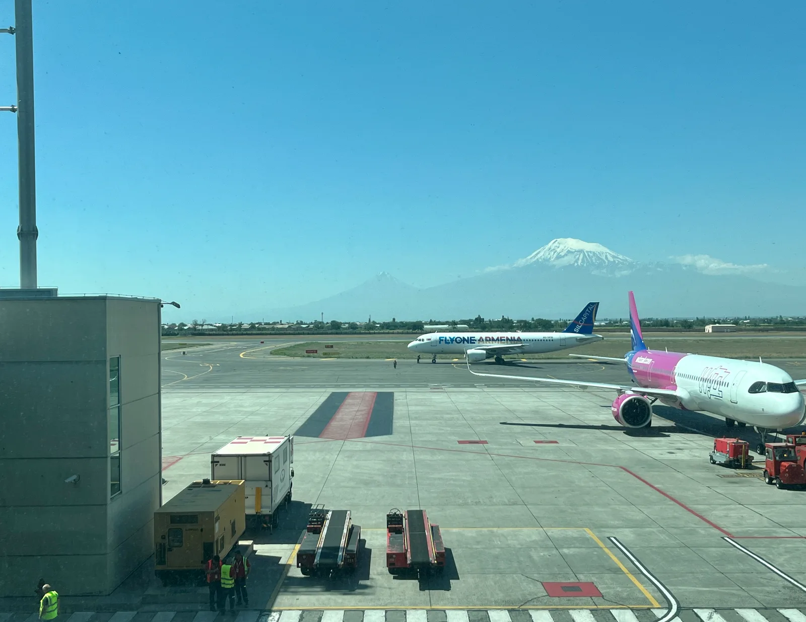 A FlyOne Armenia and a Wizz Air aircraft parked side by side on the apron at Zvartnots airport in Yerevan