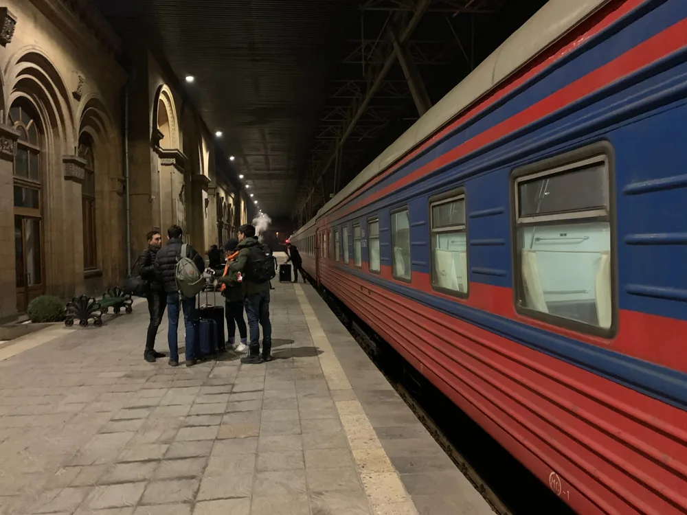 The blue carriages of the overnight train between Tbilisi and Yerevan standing at a platform