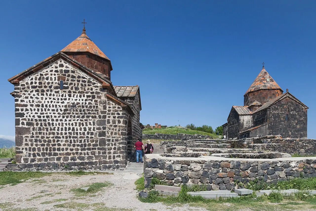 The twin medieval churches of Sevanavank on a green peninsula above the deep blue water of Lake Sevan