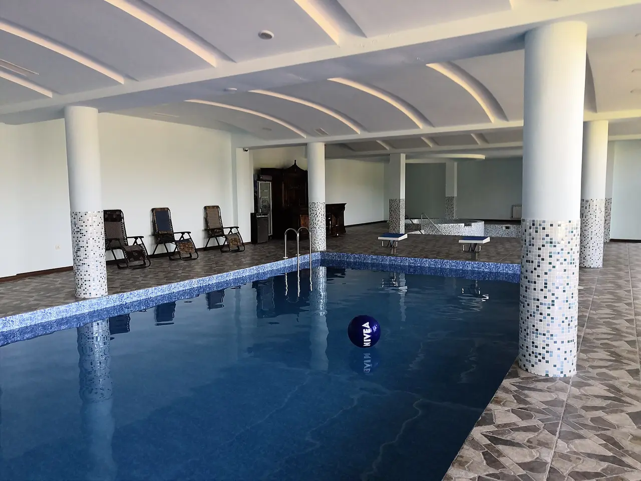 The columned indoor swimming pool of a spa hotel in Jermuk with loungers along the wall