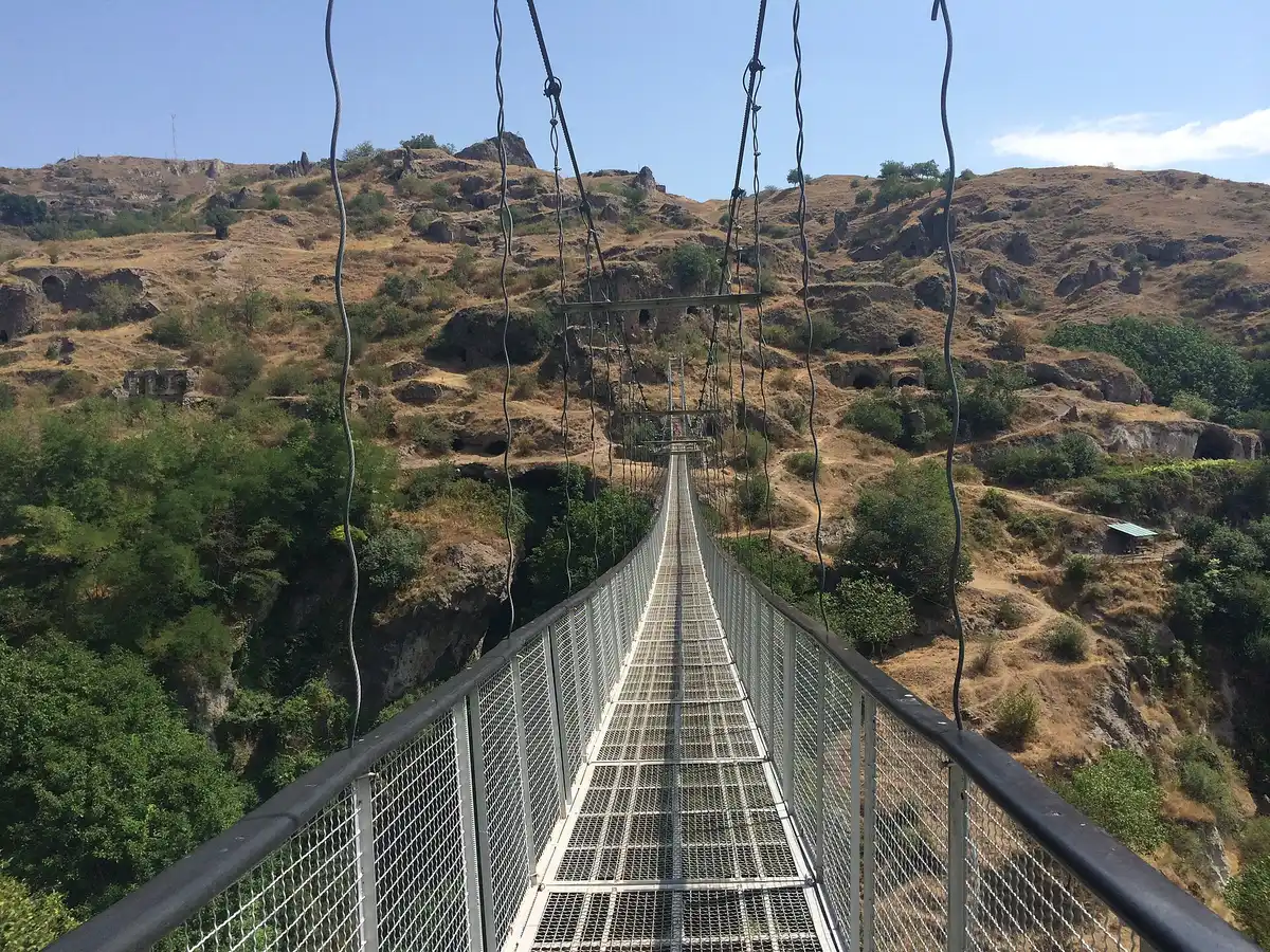 The long swinging suspension bridge of Old Khndzoresk strung across the green Khor Dzor gorge