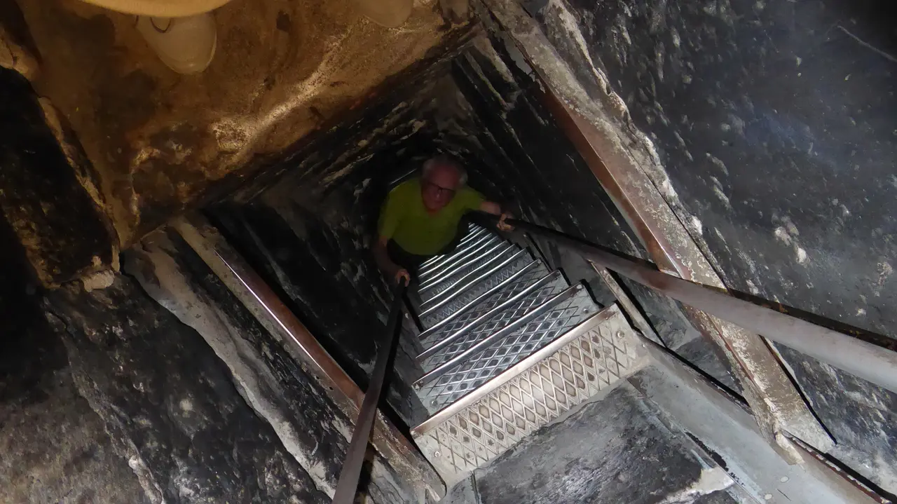A visitor climbing the narrow metal ladder up out of the deep pit where Gregory the Illuminator was imprisoned, under the St Gevorg chapel at Khor Virap