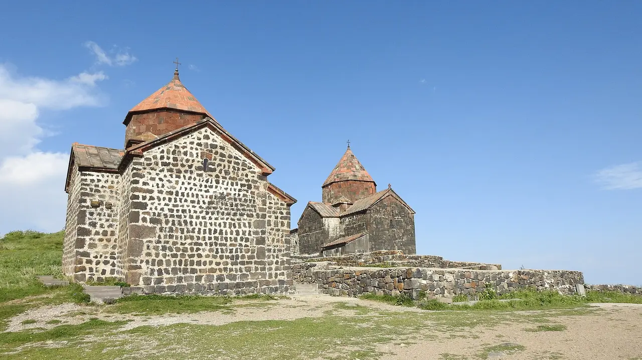 The two dark-stone churches of Sevanavank on their peninsula above the blue water of Lake Sevan