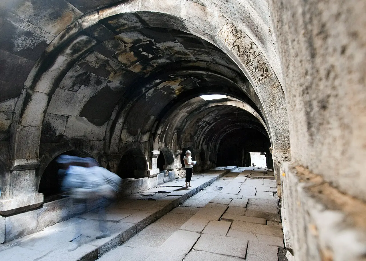 The dark basalt hall of Orbelian caravanserai with its rows of stone pillars and vaulted roof