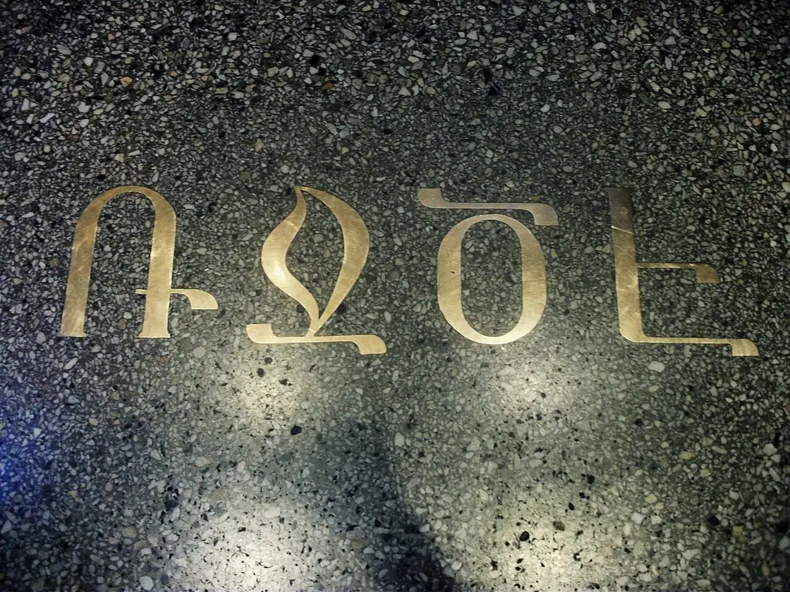 A brass inscription set into the stone courtyard at the entrance of the Matenadaran