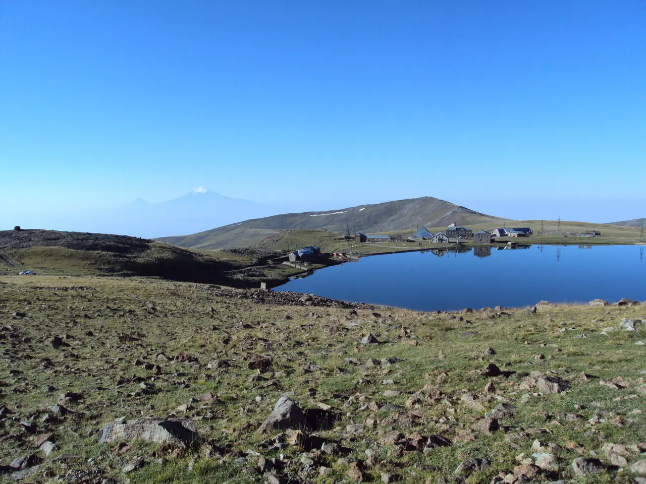 The distant snow-capped cone of Mount Ararat seen across the plain from the slopes of Aragats