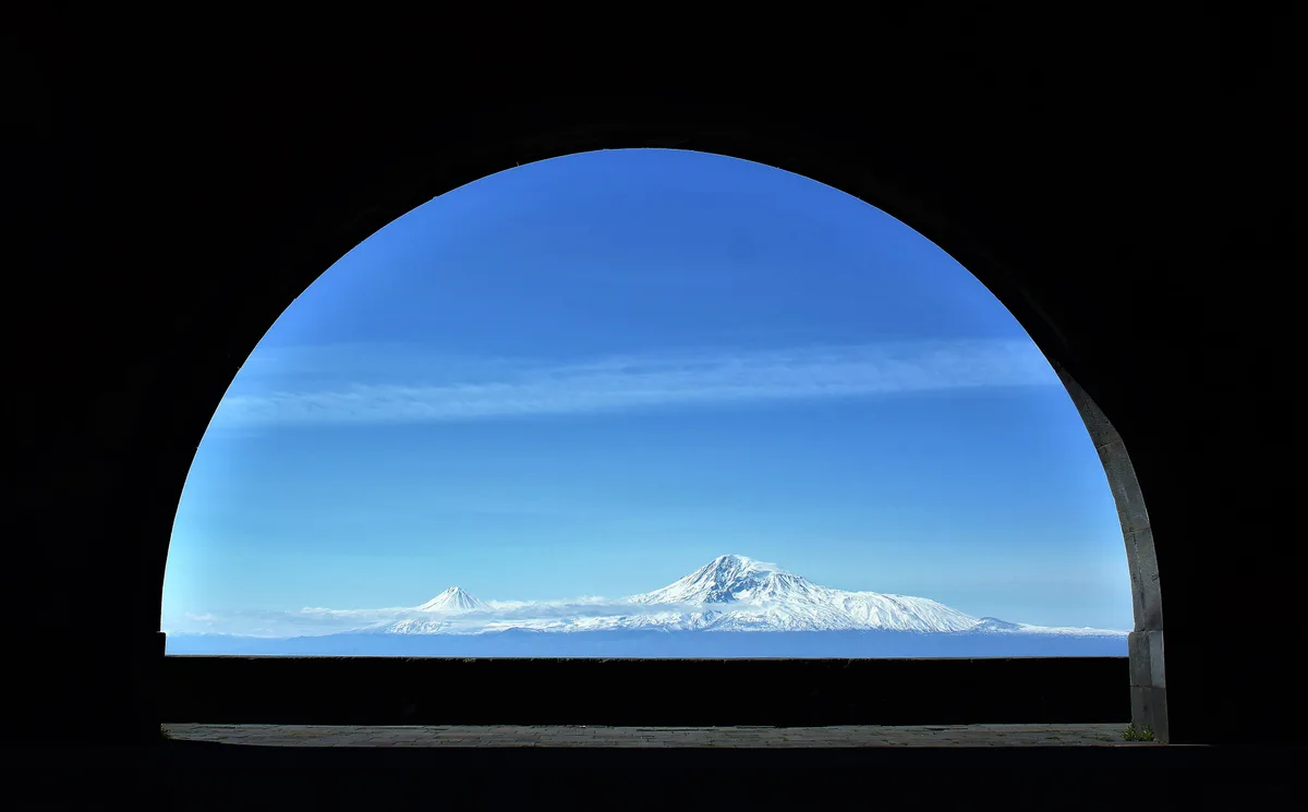 Mount Ararat framed inside the stone opening of the Arch of Charents on the old road from Yerevan to Garni