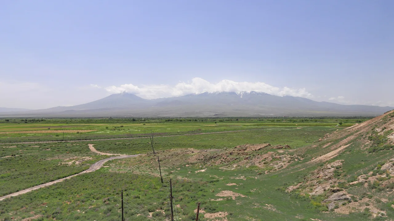 The snow-capped double cone of Mount Ararat rising above the walled monastery of Khor Virap and the vineyards of the Ararat plain