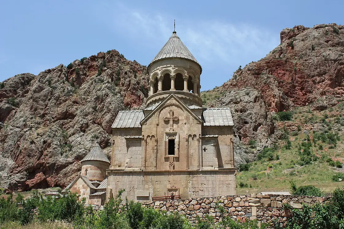 The Burtelashen church at Noravank seen head-on, its lantern belfry rising against the red canyon walls on either side
