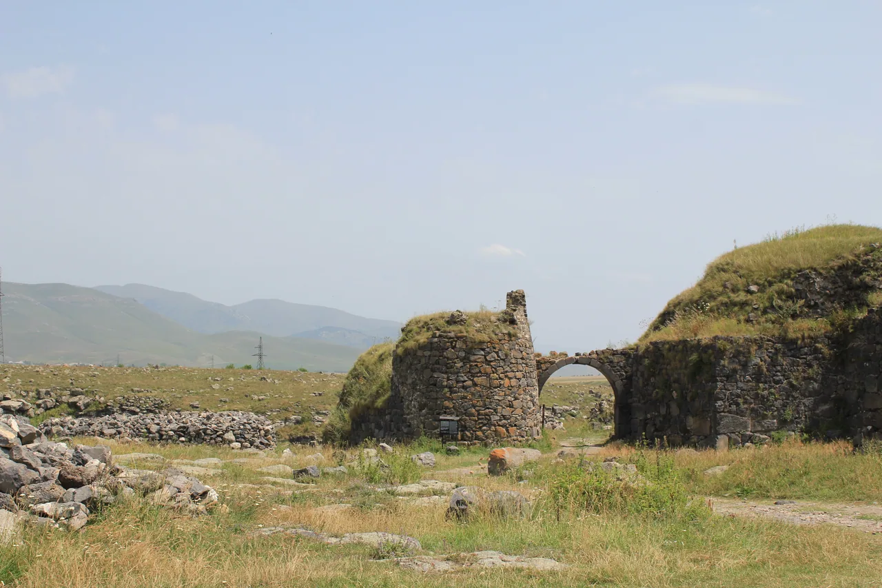 The ruined stone walls of Lori Berd fortress on a grassy promontory above a river gorge near Stepanavan