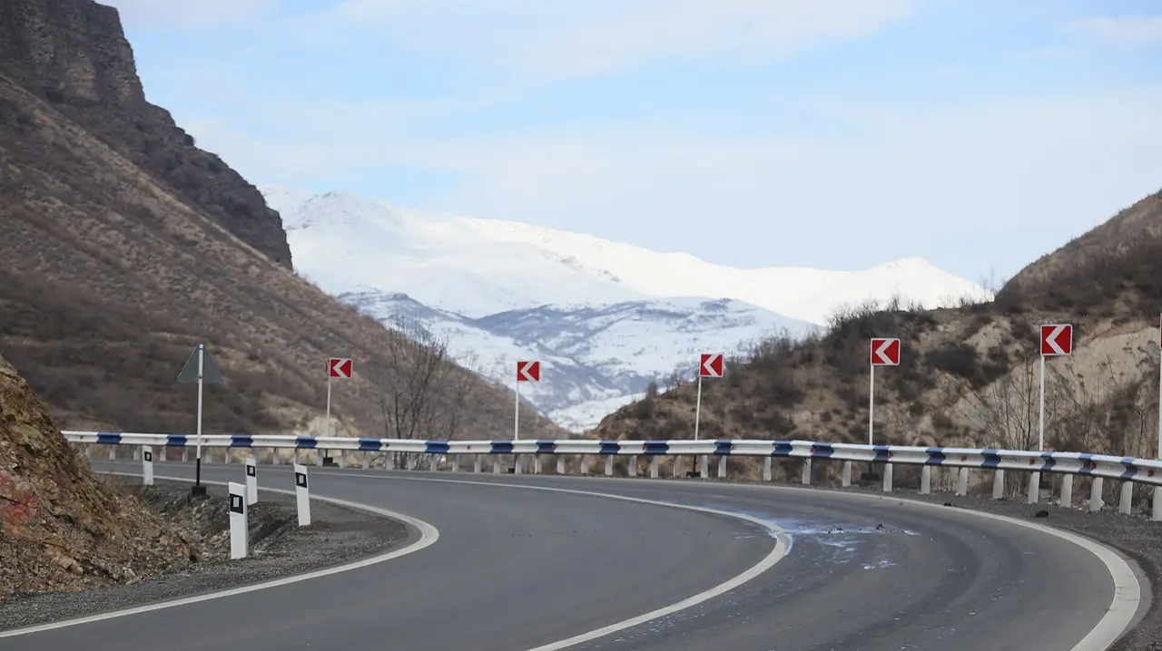 A smooth curving highway heading toward snow-capped mountains in northern Armenia, the M6 road to the Georgian border
