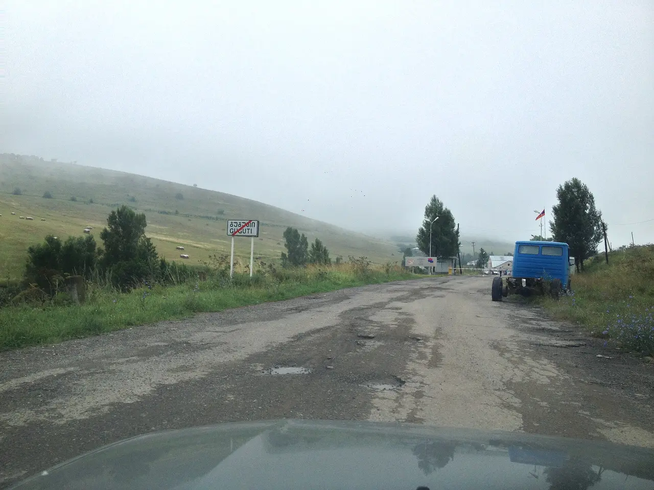 A view from a car approaching a misty border checkpoint in the hills between Georgia and Armenia