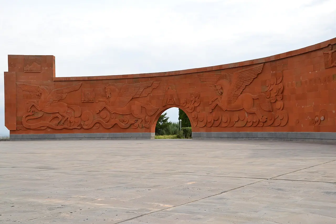 The curved memorial wall at Sardarapat with bas-relief figures in red tufa