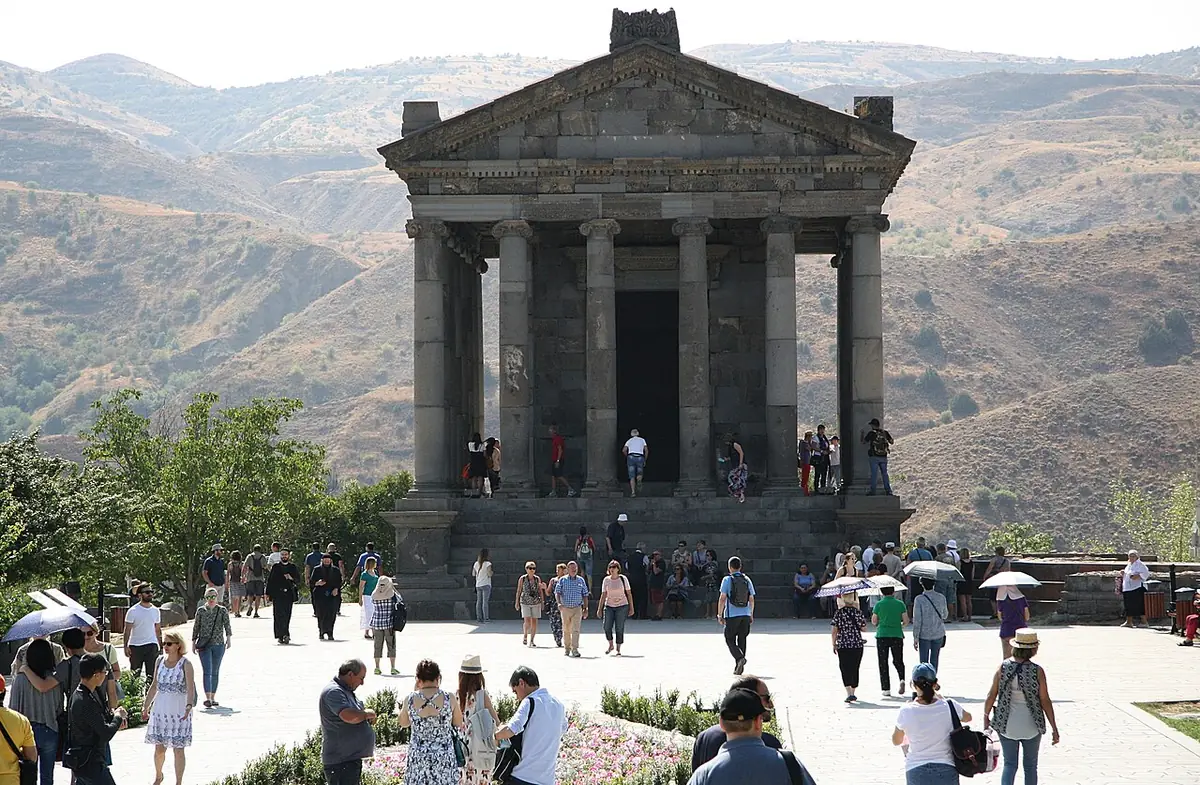 Visitors walking among the columns of the Hellenistic temple at Garni