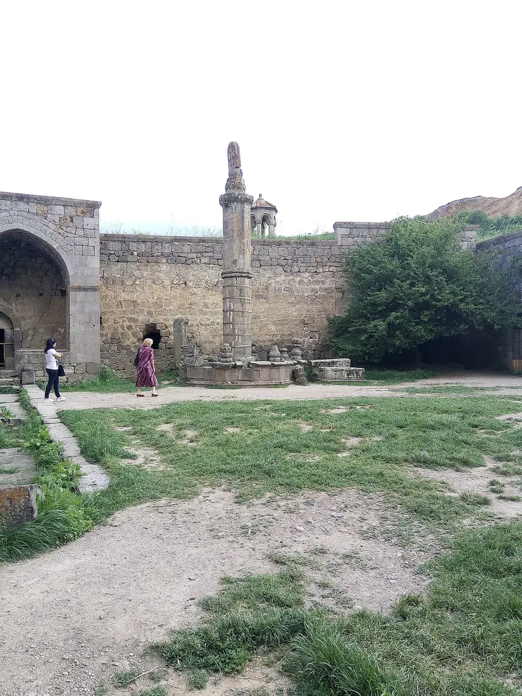 The tall octagonal Gavazan stone column standing in the courtyard of Tatev monastery, topped with a carved khachkar