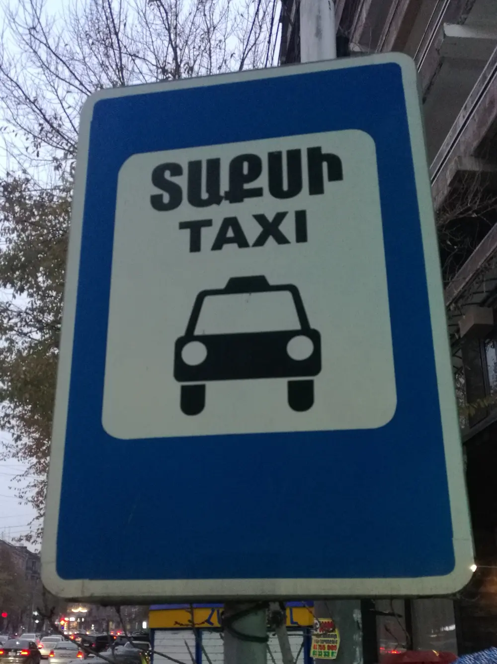 A blue Armenian and English TAXI street sign at a taxi stand in Yerevan