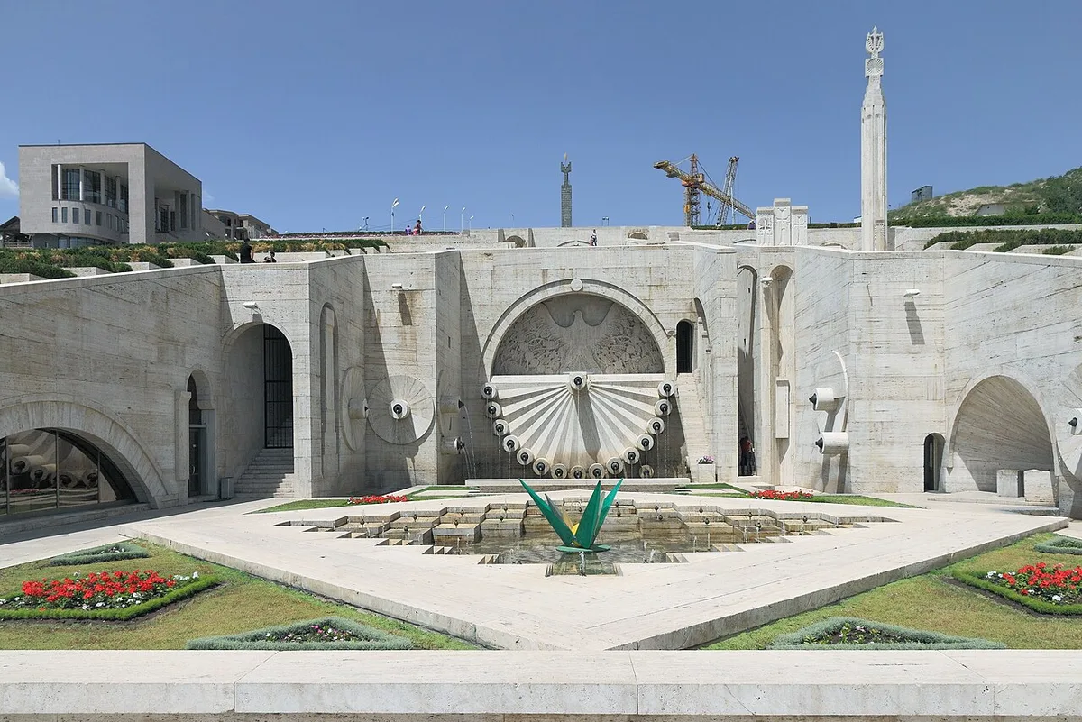 The limestone steps and sculpted fountain wall of the Yerevan Cascade climbing above the city, with the Mother Armenia spire in the distance