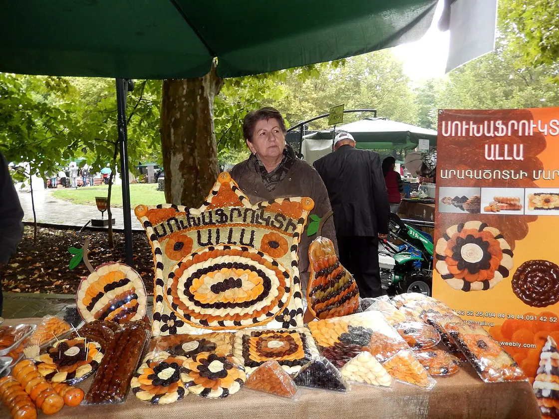 A vendor presenting colourful dried fruits and sujukh at the GUM covered food market in Yerevan