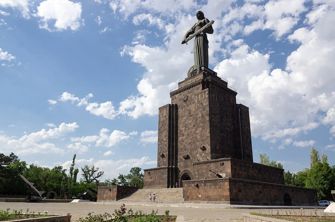 The Mother Armenia statue, a woman holding a sword, standing on a stone plinth in Victory Park above Yerevan