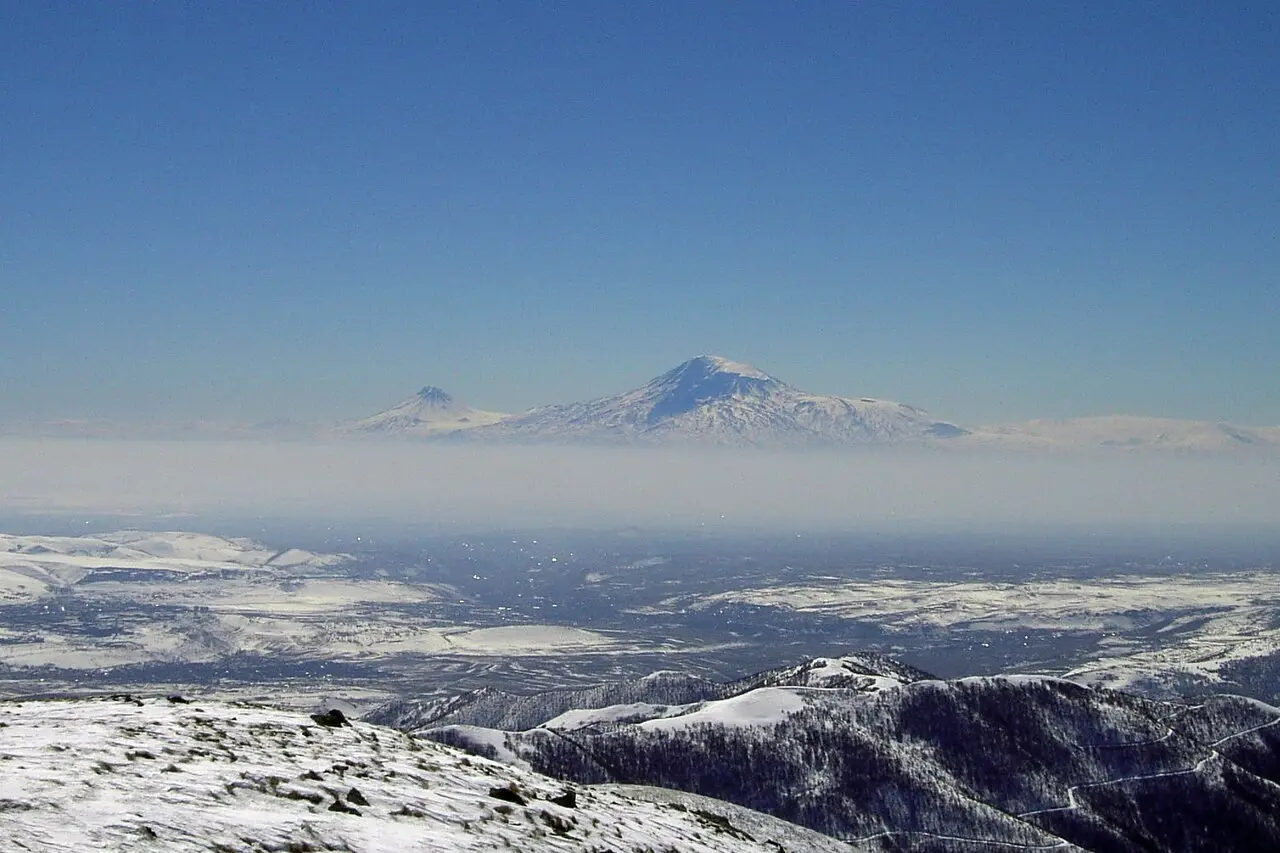 Mount Ararat rising above a sea of haze seen from the snowy heights of the Tsaghkunyats range above Tsaghkadzor