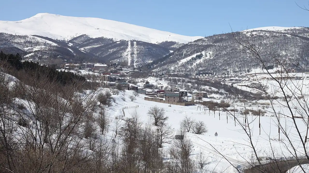 The snow-covered town of Tsaghkadzor in its valley with the ski slopes and lifts cut into Mount Teghenis behind