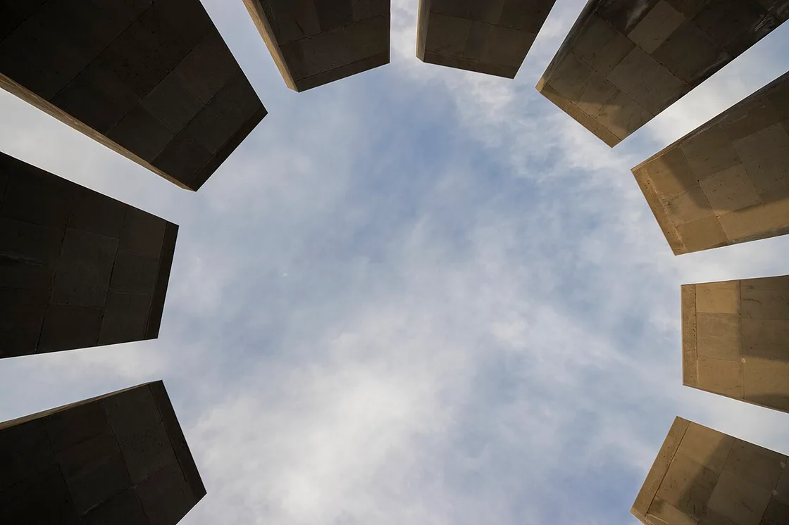 Looking up from inside the ring of twelve leaning basalt slabs at Tsitsernakaberd towards the open sky