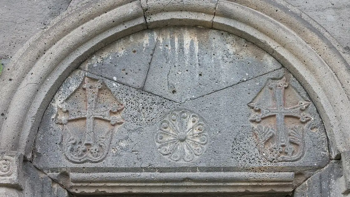 A carved stone tympanum at Haghpat with two crosses and a rosette cut into the arch above a doorway