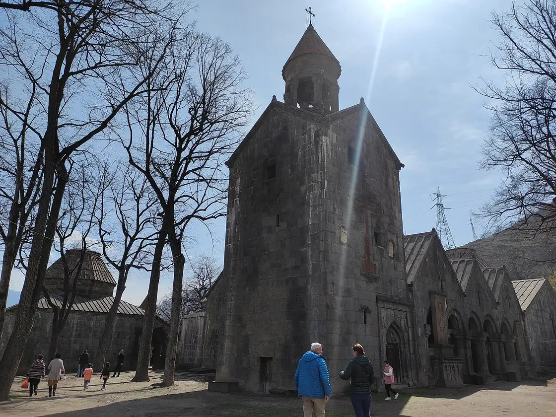 The grey stone bulk of Sanahin monastery with its domes and covered galleries under bare trees