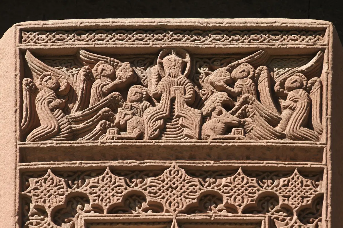 A row of carved khachkars (cross-stones) set against a wall in the grounds at Vagharshapat