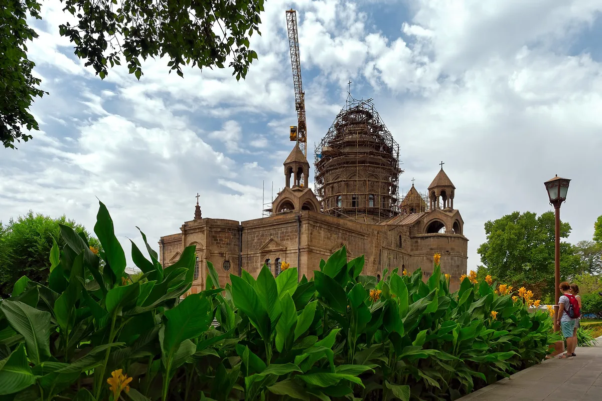 The courtyard and buildings of the Mother See of Holy Etchmiadzin with visitors and khachkars