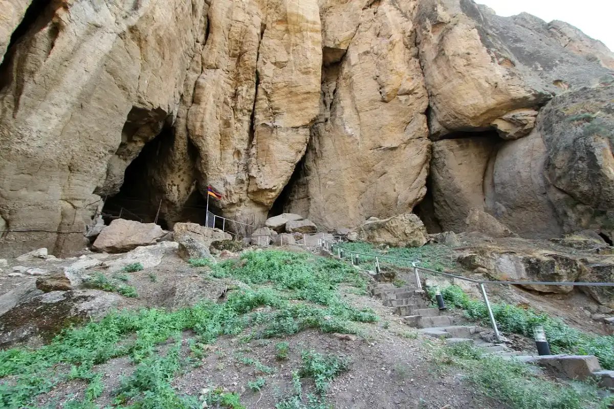 The pale cliff mouth of Areni-1 cave above the Arpa river near Areni