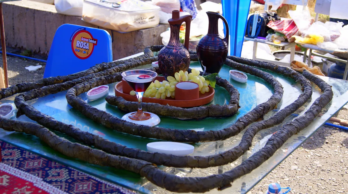 Cooks serving tolma and stuffed vegetables at an outdoor Armenian food festival stall