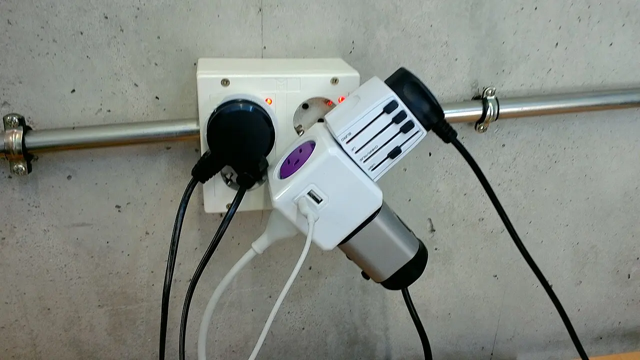 A cluster of European power plugs and a socket splitter on a desk
