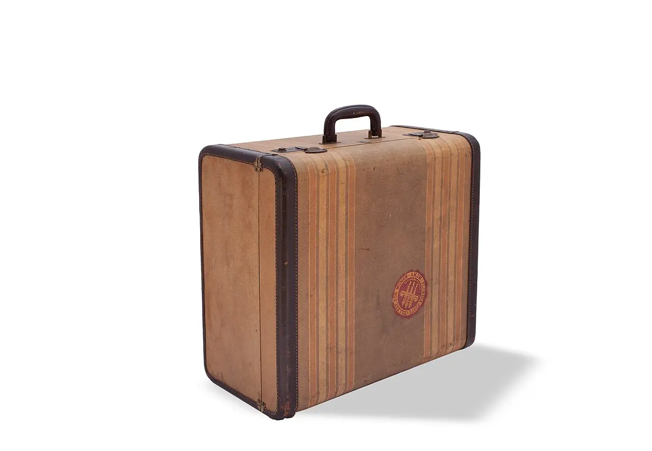 A vintage striped hard-shell suitcase standing open on a wooden floor