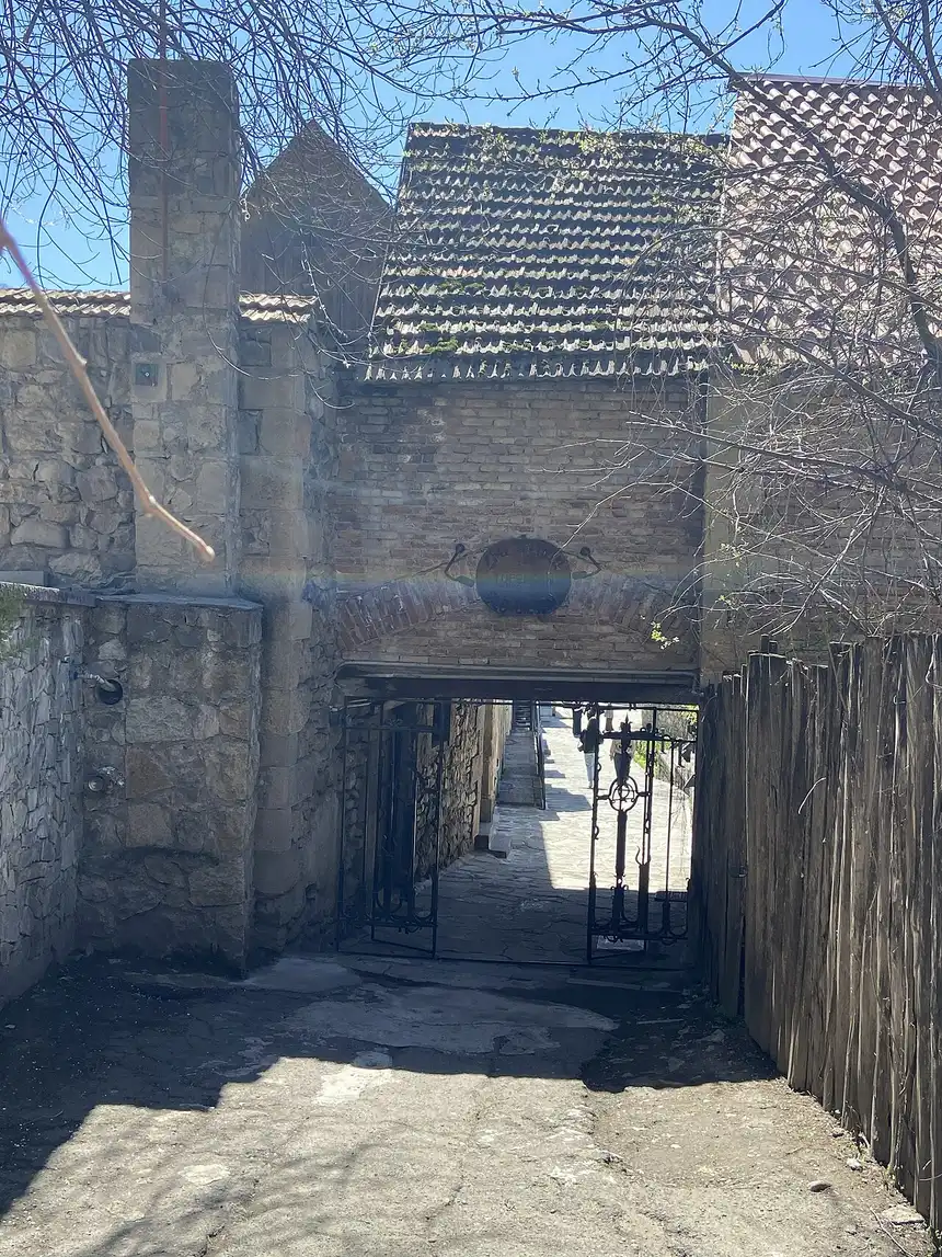 The stone gateway into the restored Sharambeyan Street old quarter of Dilijan under a blue spring sky