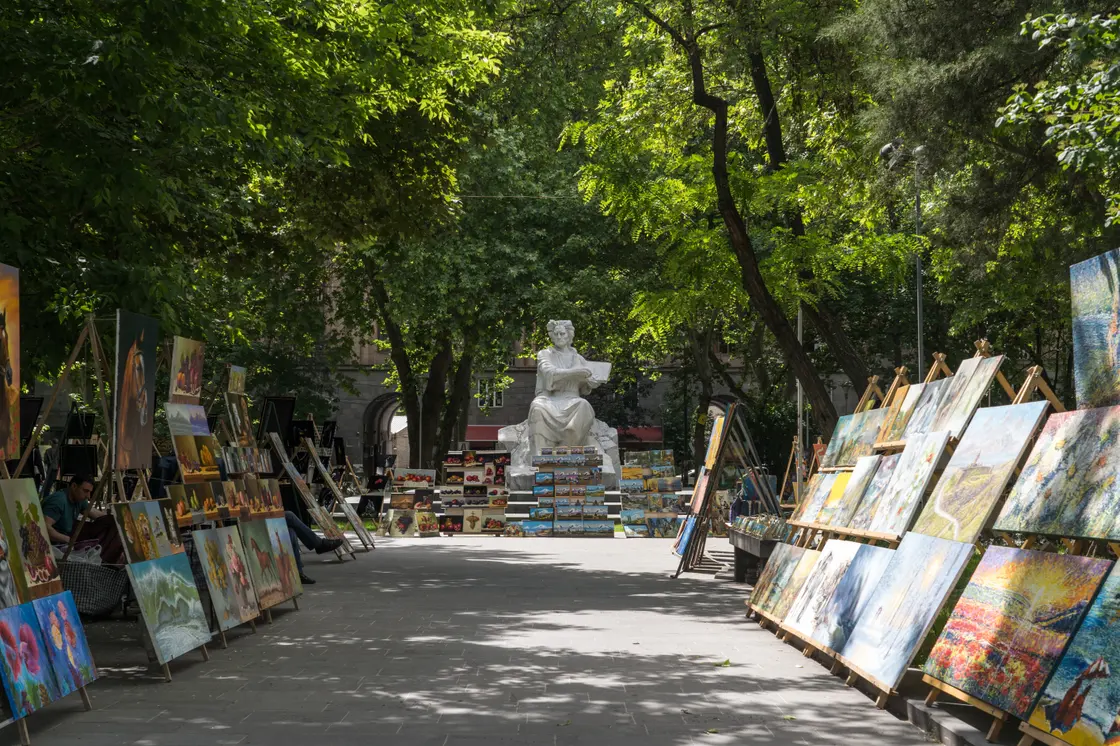 Green trees and outdoor cafe seating along Saryan Street near the Opera in central Yerevan