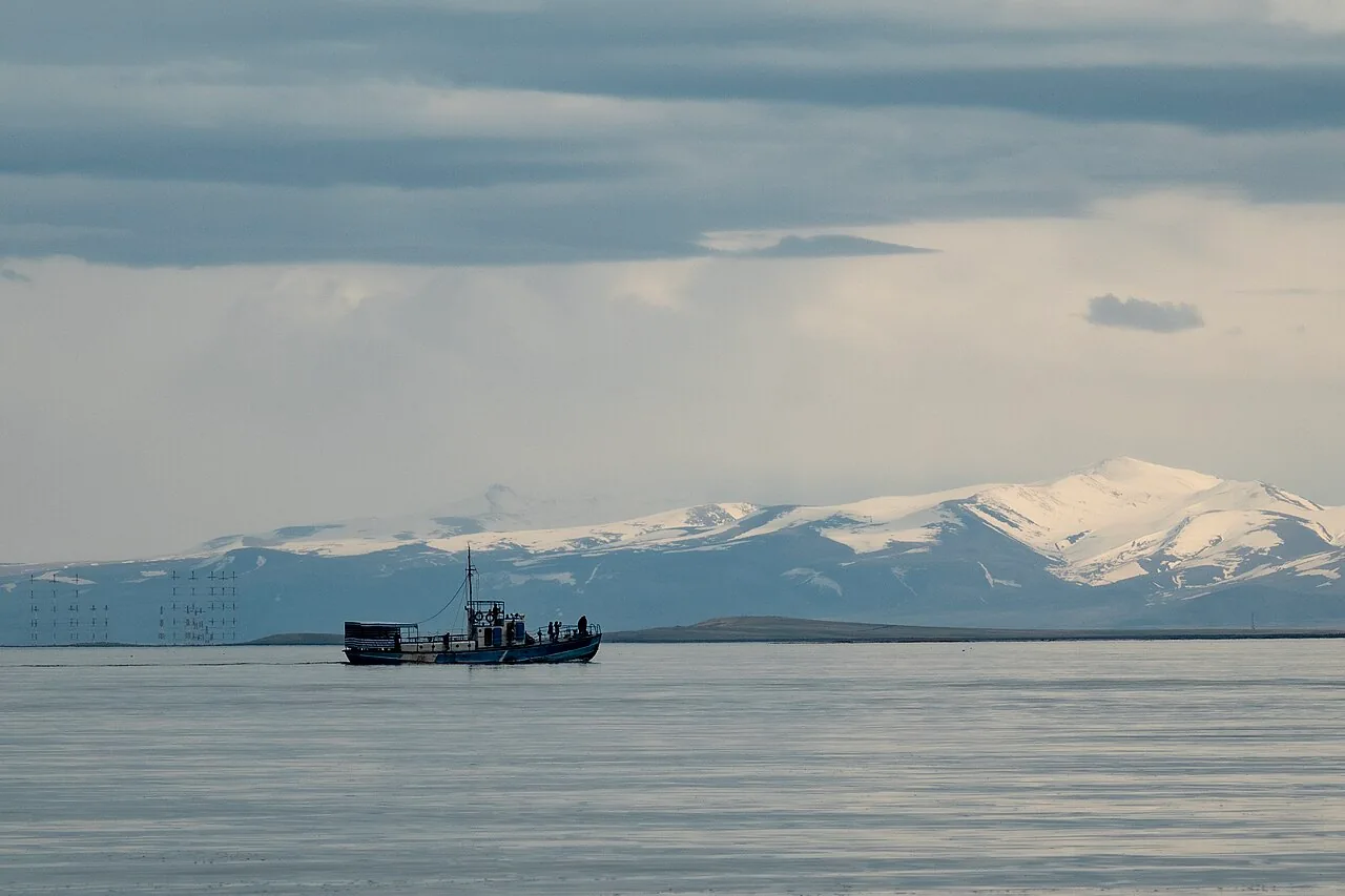 A small boat on the calm water of Lake Sevan near the shore