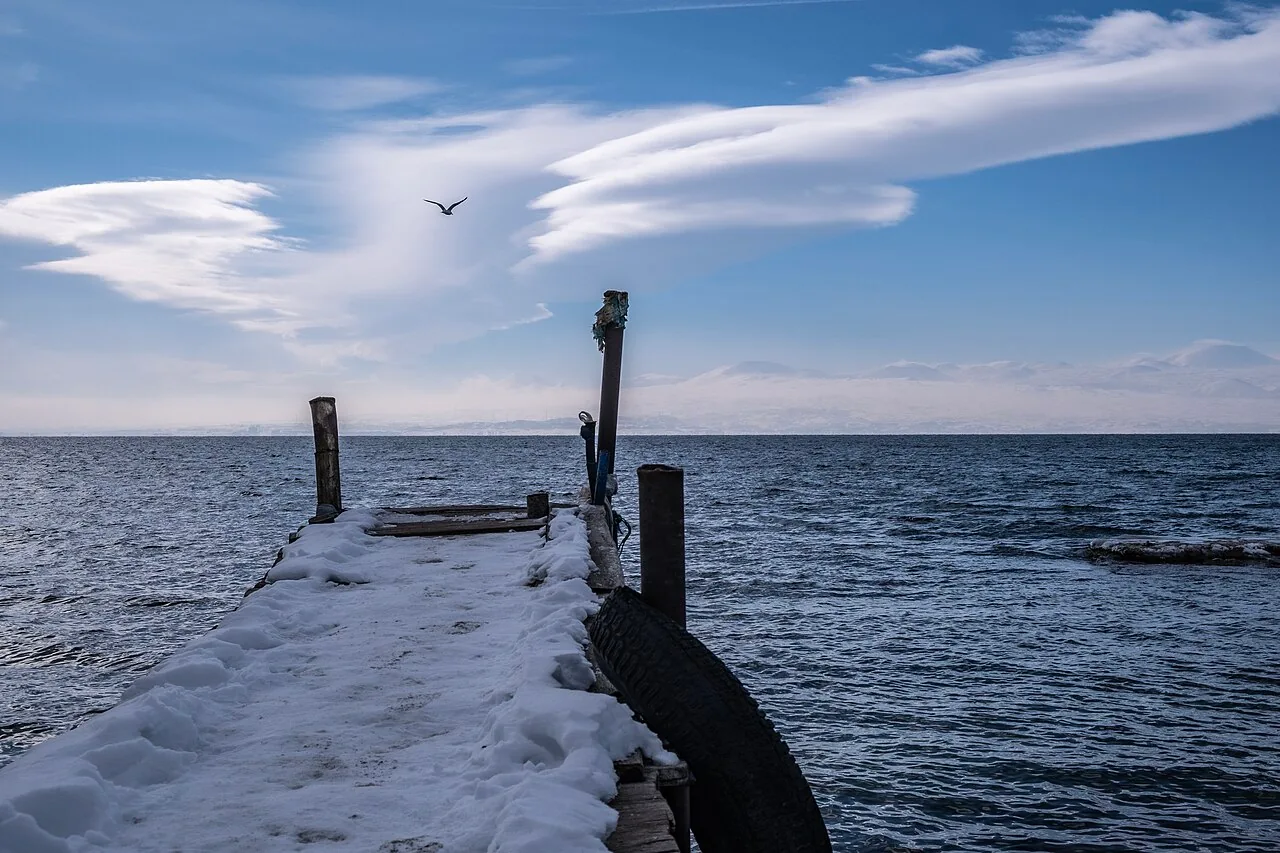 A wooden pier reaching out into the blue water of Lake Sevan