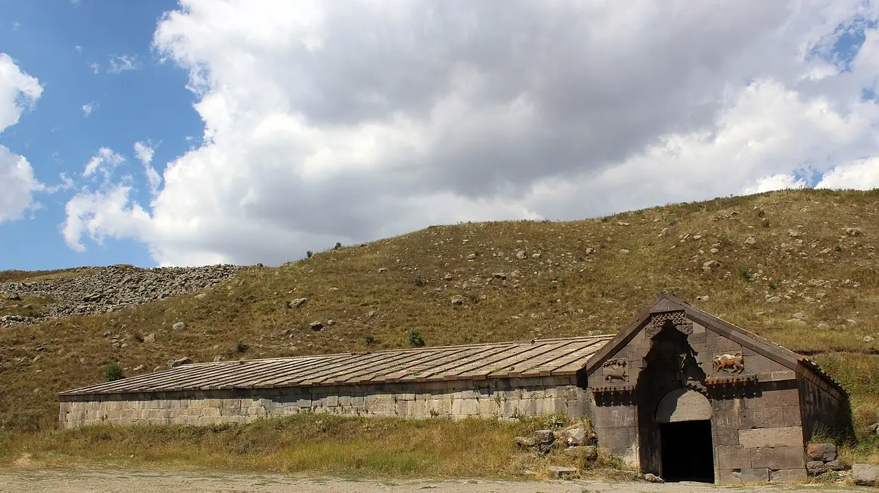 The long basalt hall of Orbelian caravanserai on the Selim Pass under a wide mountain sky in Vayots Dzor