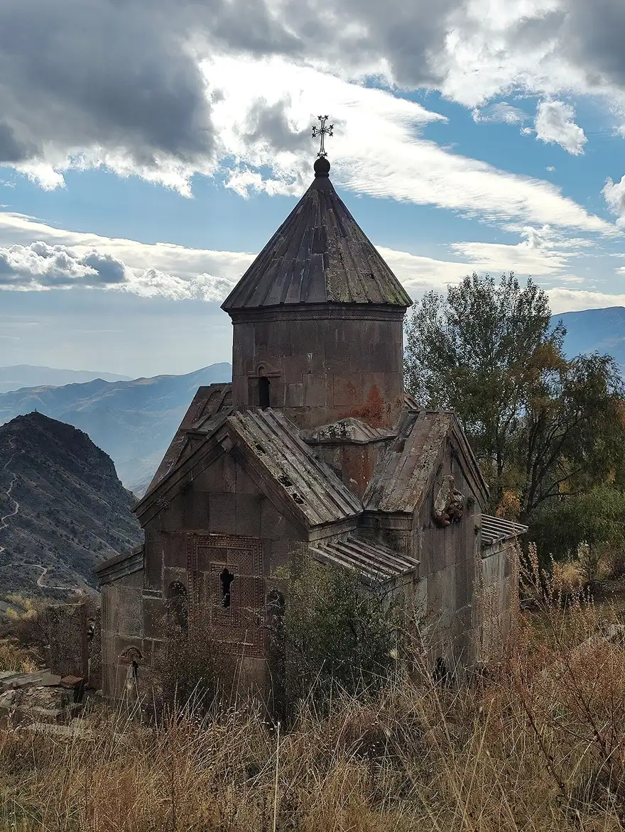 The domed Holy Mother of God church of Tsakhats Kar monastery on a grassy mountainside above the valley