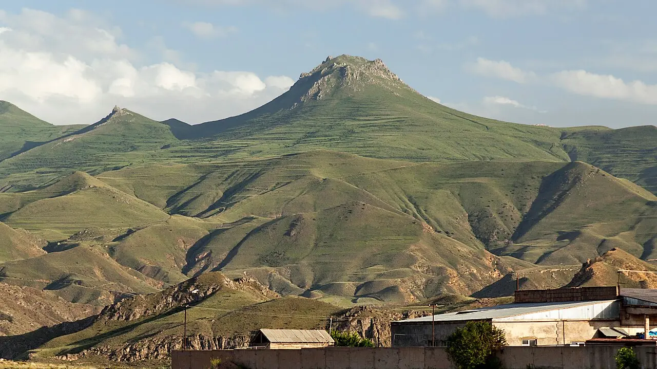 Green terraced mountain ridges rising above the rooftops on the edge of Yeghegnadzor