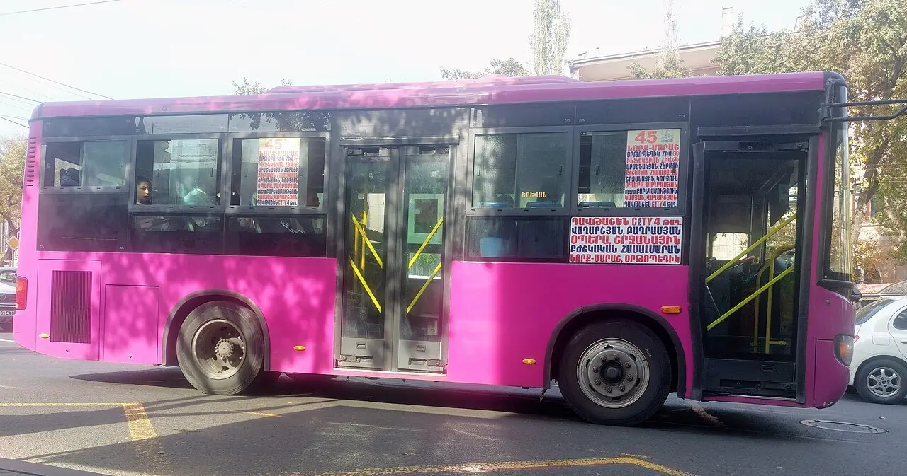 A bright pink Yerevan city bus on route 45 with Armenian route signs in the windows