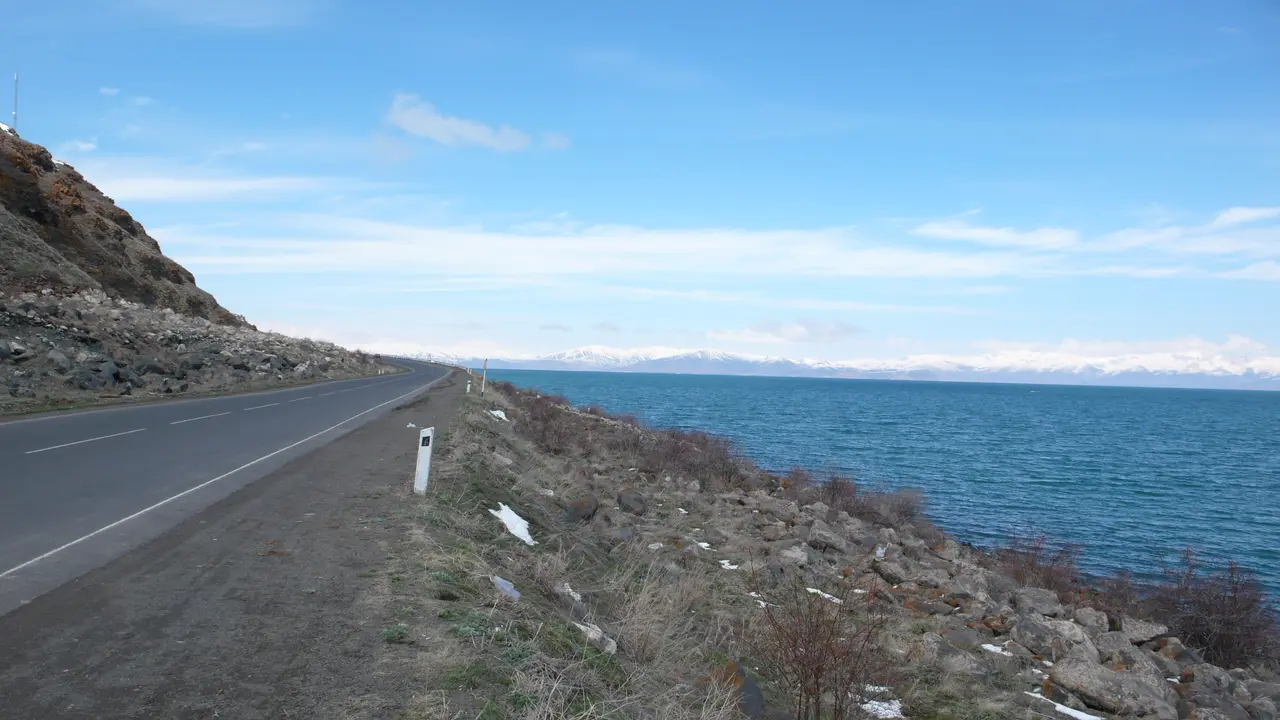 The M4 road running along the shore of Lake Sevan with snow-capped mountains across the water