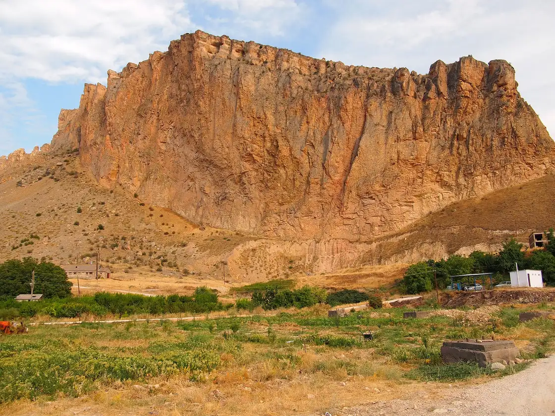 A towering golden cliff rising over the village of Areni in Vayots Dzor, a landmark on the drive south