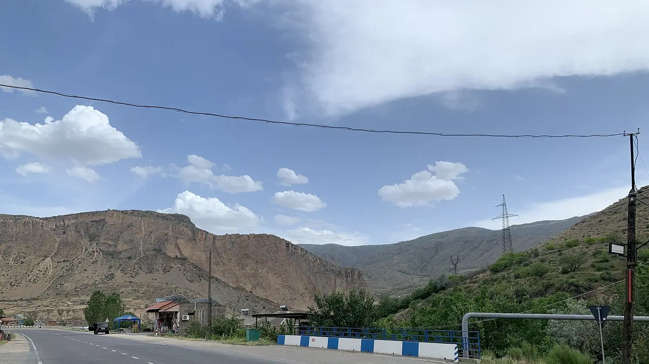 The M2 highway running past the tall red cliffs of Vayots Dzor near Areni on the road south toward Jermuk