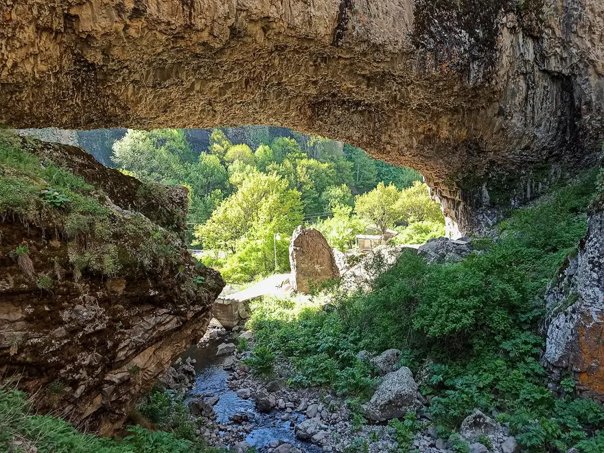 A natural rock arch over a stream in the wooded Arpa gorge at Jermuk