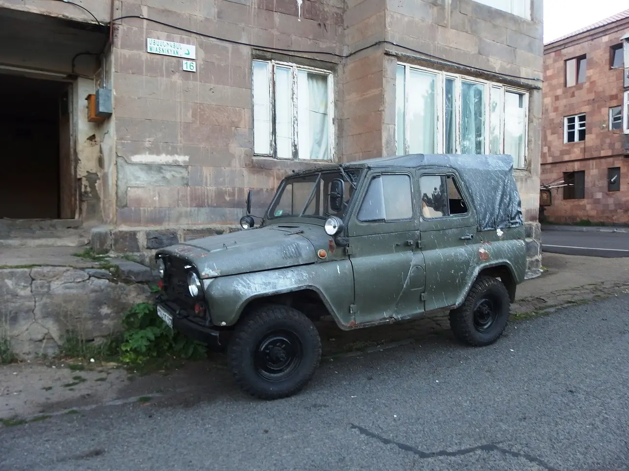 An old Soviet UAZ jeep parked on a quiet street in Jermuk